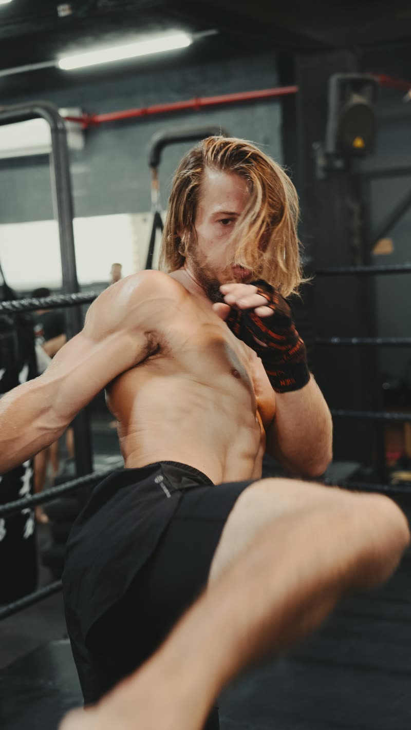 Lutador de muay thai treinando golpes no ringue
